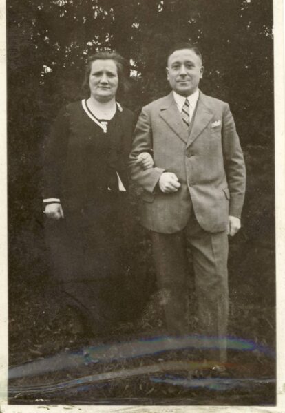 Historisches Foto eines Ehepaars. Links die Frau im schwarzen Kleid, rechts der Mann, im Anzug mit Hemd und Krawatte. Die Frau hat ihren Arm beim Mann eingehängt.